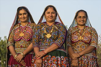 Three Ahir women in traditional colorful clothes