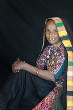 Elderly Ahir woman in traditional colorful clothes with a nose ring