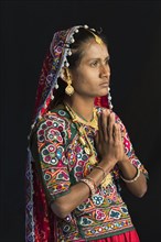 Ahir woman in traditional colorful clothes praying