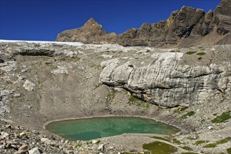 Lake of green meltwater in a doline or sinkhole in the end moraine of Tsanfleuron Glacier at Sanetsch Pass