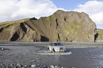 All-terrain vehicle crossing the glacial river of Krossá