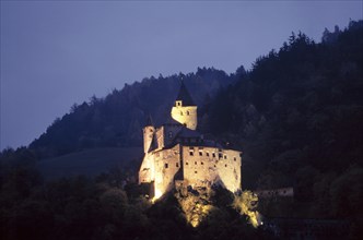 The illuminated Trostburg Castle at dusk