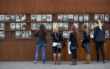 Visitors in front of photos of victims of the Berlin Wall