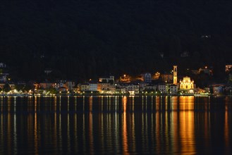 Village of Porto Ceresio with the Parish Church of Chiesa Sancto Ambrosio on Lake Lugano or Lago di Lugano at night