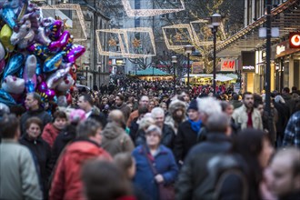 Crowds thronging between stores and Christmas market stalls