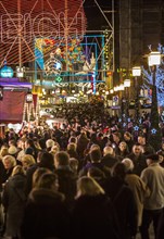 Crowds thronging between stores and Christmas market stalls