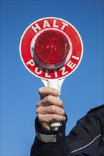 Policeman holding a police signalling disc