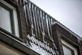 Large icicles hanging from the eaves of a house