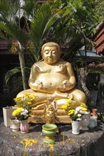 Golden Buddha statue in the garden of the Wat Phra Singha temple
