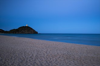 Baia di Chia beach with the Saracen Tower at dusk