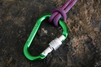 Carabiner with safety rope on a stone surface