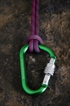 Carabiner with safety rope on a stone surface