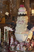 Santa Claus figure with a cake on its head