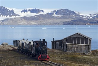 Historic mine train in Ny Alesund against the backdrop of Kongsfjorden or Kings Bay