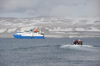 Passengers returning after being ashore in Zodiac inflatable boats to the expedition cruise ship