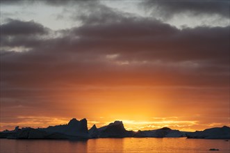 Sunset behind icebergs