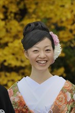Japanese woman wearing a kimono for spring with a kimono collar and an updo hairstyle with chrysanthemums