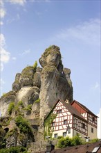 Half-timbered house next towering karst rocks