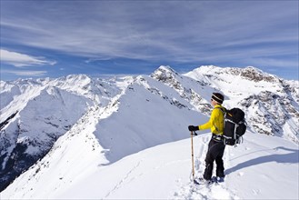 Cross-country skier on the summit of Ellesspitze Mountain in Pflerschtal valley
