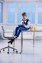 Boy with a tablet PC sitting on a desk