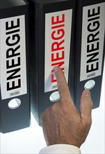 Hand pointing to a ring binders labeled Energie