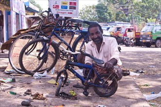 Indian man repairing a children's bicycle