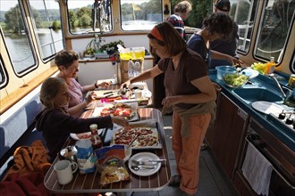 Joint preparation of lunch in the lounge of a Penichette houseboat on the Saône River