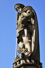 Sandstone statue of St. Florian against a blue sky