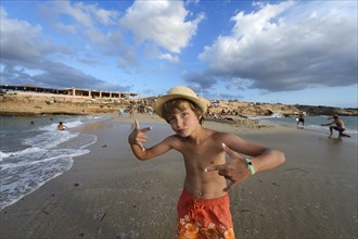Boy rapping on the beach in front of Cala Comte