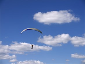 Paragliding in the summer sky with clouds