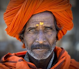 Man with and orange turban and yellow bindi on his forehead
