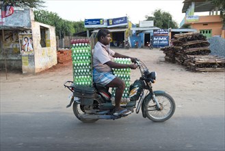 Man riding a scooter laden with eggs