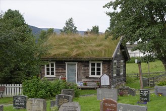 House with a grass-covered roof at a cemetery