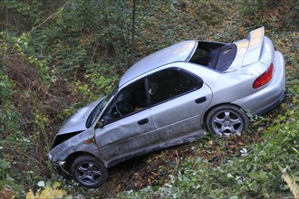 Car which has driven off the road and down an embankment