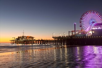 Ferris wheel at Pacific Park on the Santa Monica Pier and the beach in Santa Monica at dusk