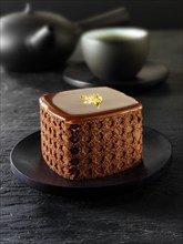 Cake with a sponge case and chocolate filling in a black Japanese tea setting