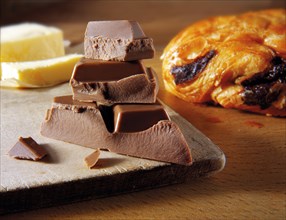 Chocolate pieces next to a chocolate croissant
