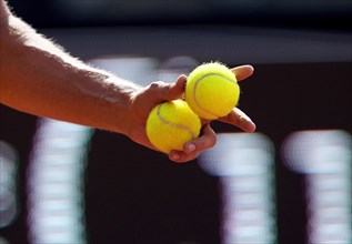 Tennis player holding tennis balls in his hand