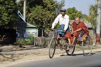 Buddhist monk on bicycle rickshaw or trishaw