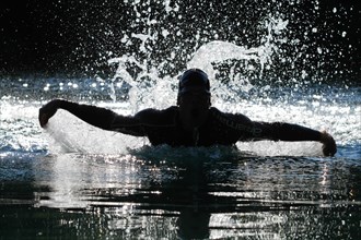 Man swimming with a butterfly stroke in a lake in Sonthofen