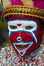 Member of a tribe in a colourfully decorated costume with face paint is celebrating at the traditional Sing Sing gathering in the highlands