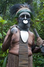 Tribal chief wearing a traditional dress holding a spear
