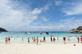 Tourists and boats on the white sandy beach of Ao Kueak
