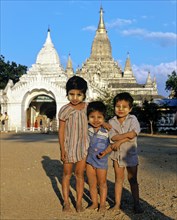 Children with Thanaka paste on their faces in front of Buddhist pagodas