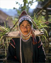 Akha woman in traditional costume and headdress with silver coins