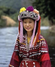 Lisu girl wearing a colourful headdress and the traditional costume of the mountain people