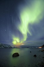 Northern Lights over fjord with winter landscape