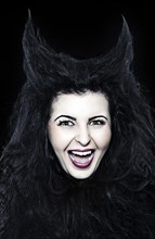 Laughing young woman dressed as a devil with horns