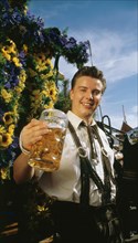 Man in Bavarian costume with a beer mug in his hand