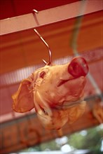 Pig's head in a display window on a hook